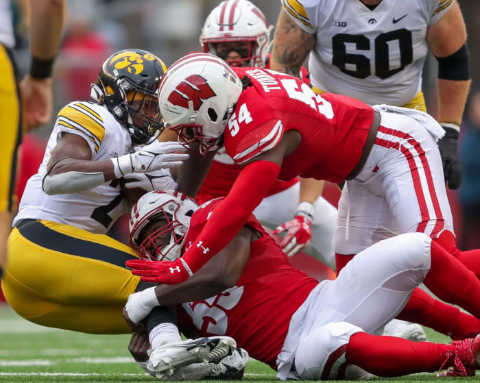 Wisconsin linebackers Maema Njongmeta (55) and Jordan Turner (54) tackle Iowa running back Kaleb Johnson (2) on Saturday, October 14, 2023, at Camp Randall Stadium in Madison, Wis. Iowa won the game, 12-6.